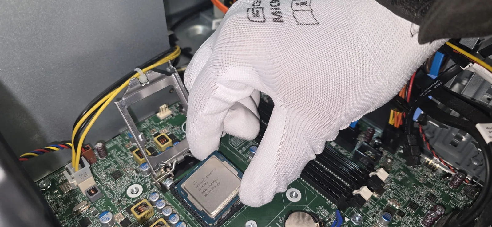 PC-Reparatur bei RefurbIT: Arbeit an einer Grafikkarte mit Schutzhandschuhen
